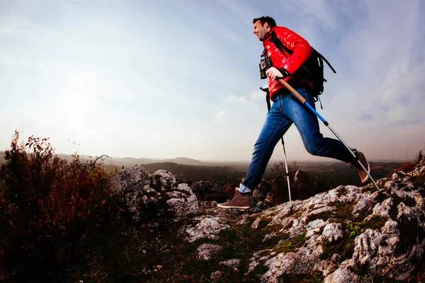 Backpacker springt auf Felsen — Stockfoto