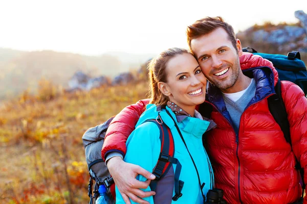 Pareja joven en las montañas sonriendo —  Fotos de Stock