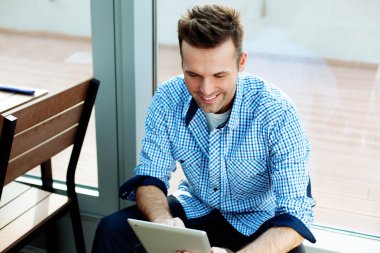 adam oturmuş ve onun tablet kullanma