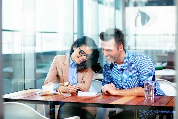 Pareja sentada en la mesa y tomando notas — Foto de Stock