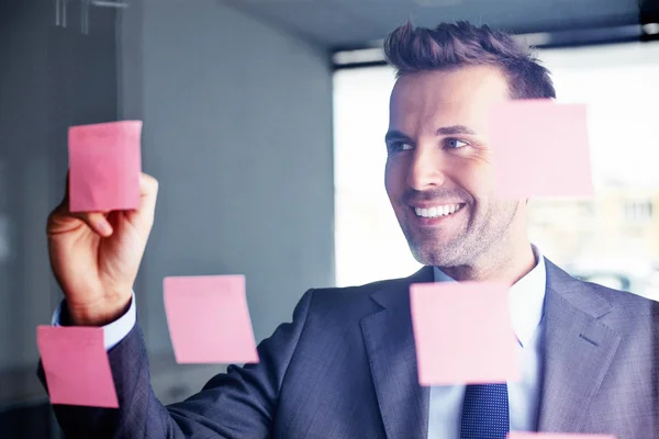 Gerente escribiendo una idea en una nota adhesiva — Foto de Stock