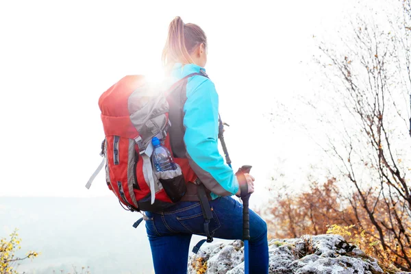 Wanderin klettert mit Stöcken — Stockfoto