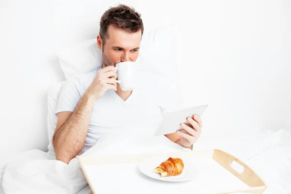 Hombre en la cama con tableta y café —  Fotos de Stock