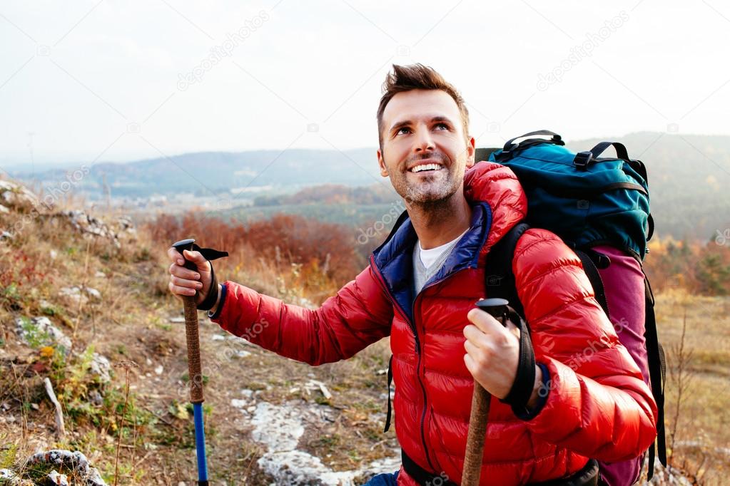Smiling hiker holding poles