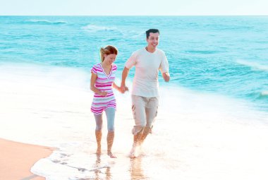 Genç çift sahilde eğleniyor.