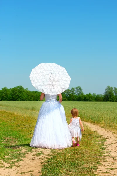 Bride with a umbrella and a child — Stock Photo, Image
