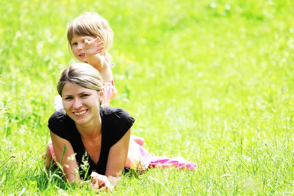 Vacker liten flicka med sin mamma på natur — Stockfoto