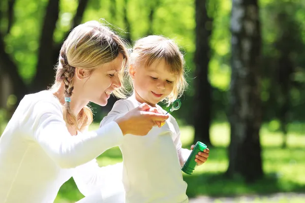 Bella bambina con sua madre sulla natura — Foto Stock