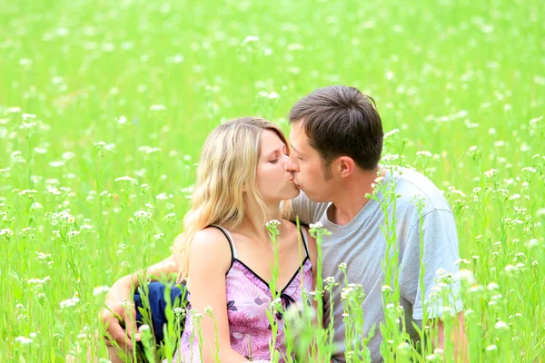 Ein junges verliebtes Paar im Gras — Stockfoto