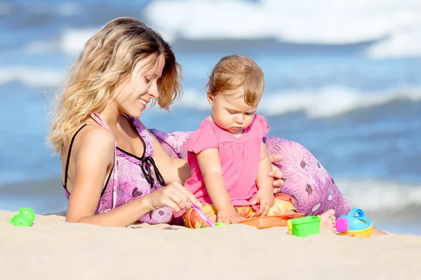 Mamma med barn vid stranden av havet — Stockfoto