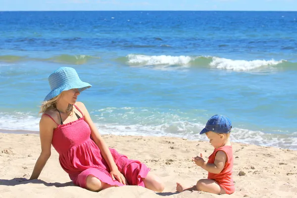 Madre con el bebé en la orilla del mar — Foto de Stock