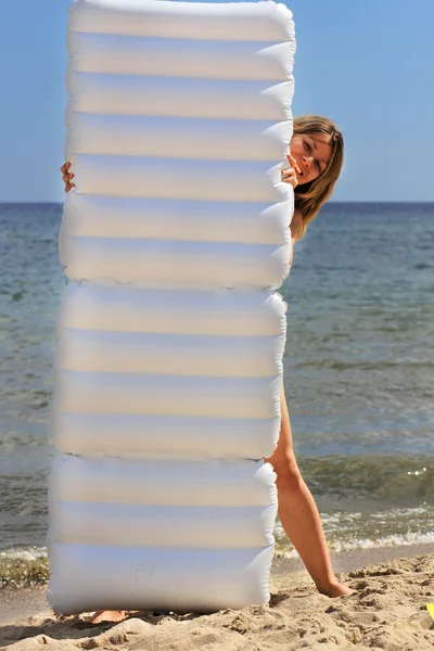 Žena s matrací na břehu moře — Stock fotografie