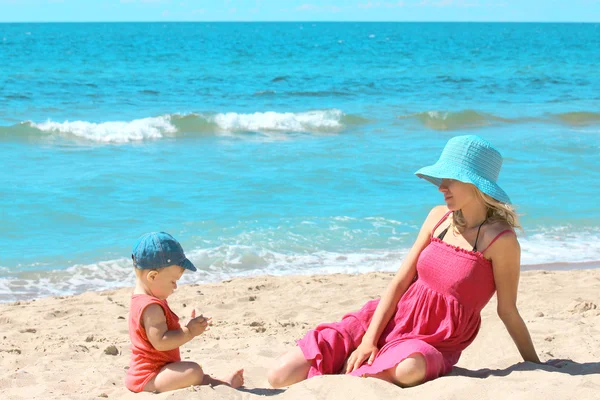 Mother with baby on the shore of the sea — Stock Photo, Image