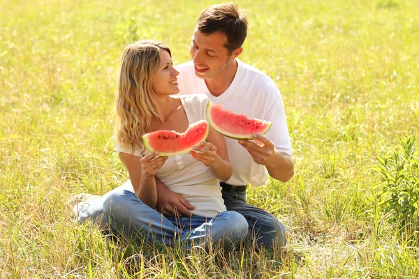 Пара влюбленных, поедающих арбуз на открытом воздухе — стоковое фото