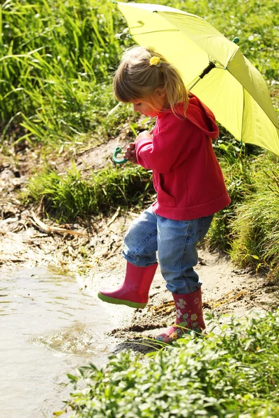 Beautiful little girl outdoors in rubber boots — Stock Photo, Image