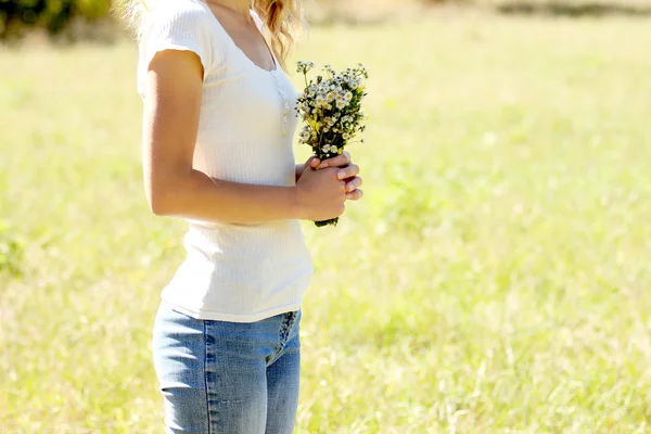 Giovane ragazza con fiori in natura — Foto Stock