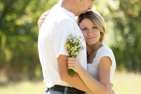 Casal apaixonado por flores na natureza — Fotografia de Stock