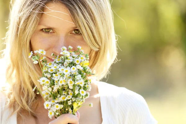 Chica joven con flores en la naturaleza — Foto de Stock