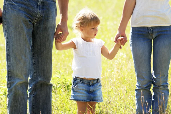Beautiful little girl holding the hand of her father and mother on the nature — Stock Photo, Image