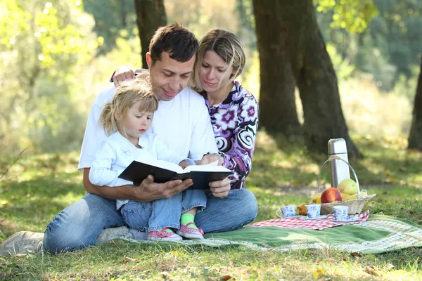 Junge Familie mit Kind beim Lesen der Bibel — Stockfoto