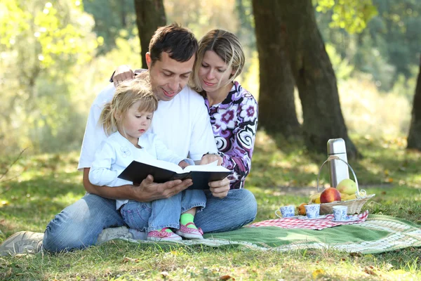 Familia joven con un niño leyendo la Biblia —  Fotos de Stock