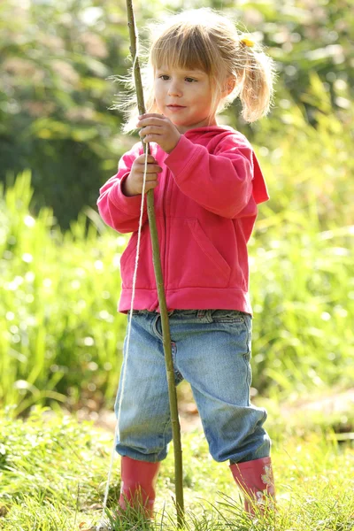 Красивая маленькая девочка в резиновых сапогах у озера — стоковое фото