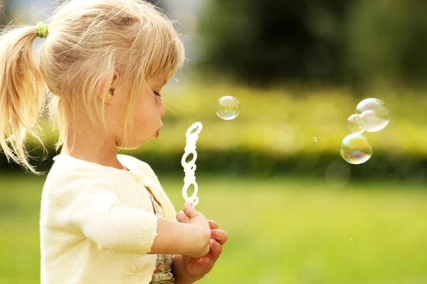 Kleines Mädchen mit Seifenblasen — Stockfoto