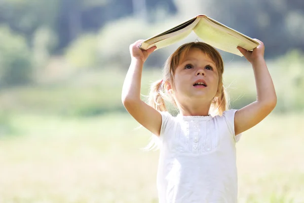 Beautiful little girl reading a book — Stock Photo, Image