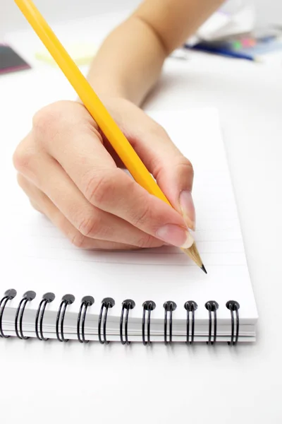 Χέρι της γυναίκας που γράφει σε ένα σημειωματάριο με στυλό — Φωτογραφία Αρχείου