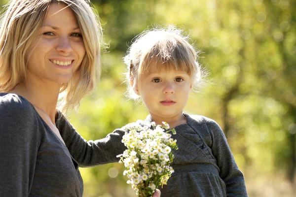 Beautiful little girl with her mother outdoors — Stock Photo, Image
