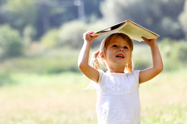 Beautiful little girl reading a book — Stock Photo, Image