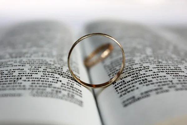 Anillo de boda acostado en una Biblia abierta —  Fotos de Stock