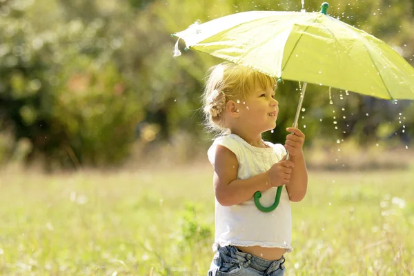 Schönes kleines Mädchen mit Regenschirm im Freien — Stockfoto