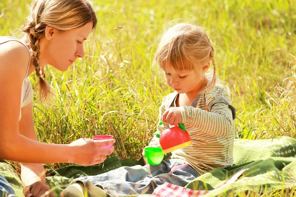 Vacker liten flicka med sin mamma utomhus — Stockfoto