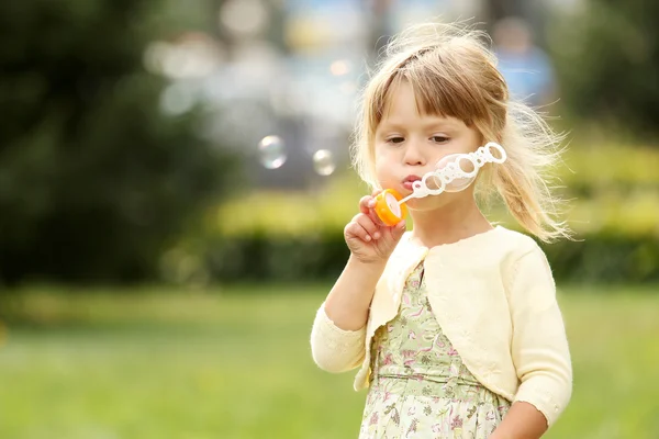 Маленькая девочка с мыльными пузырями — стоковое фото