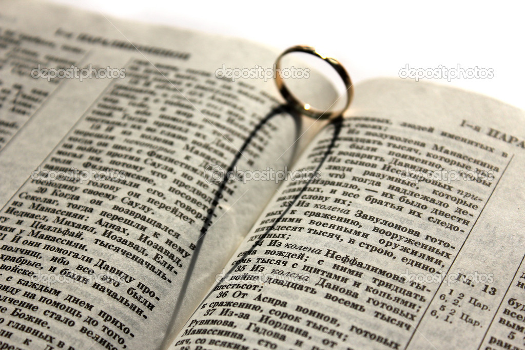 Wedding ring lying on an open Bible