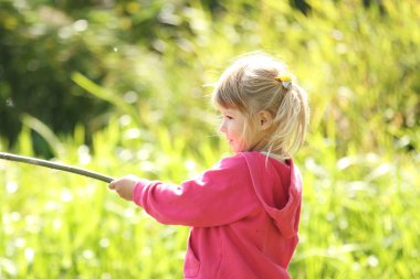 güzel küçük bir kız açık havada lastik çizme göle yakın