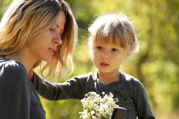 Vacker liten flicka med sin mamma utomhus — Stockfoto