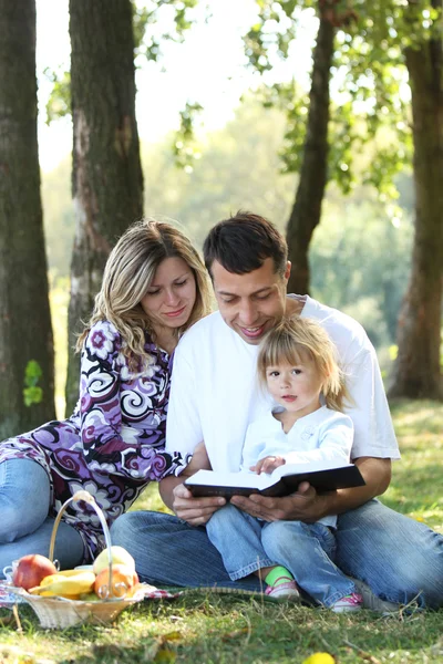 Mladá rodina s dítětem čtení bible — Stock fotografie