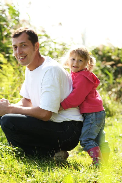 Hermosa niña con su padre en la naturaleza en un lago — Foto de Stock