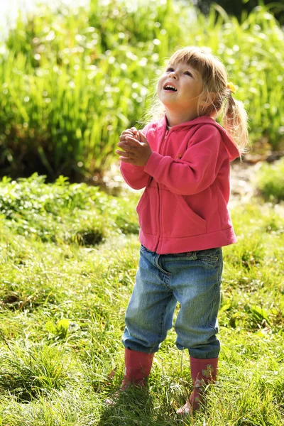 Красивая маленькая девочка на открытом воздухе возле озера в резиновых сапогах — стоковое фото