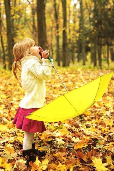 Schönes kleines Mädchen mit Regenschirm im Freien — Stockfoto