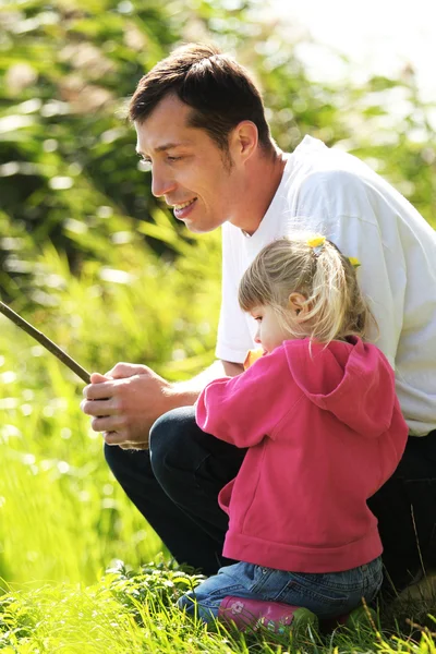 Menina bonita com seu pai na natureza em um lago — Fotografia de Stock