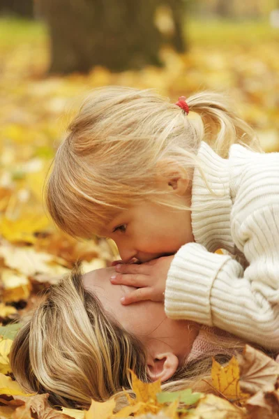 सुंदर छोटी लड़की शरद ऋतु वन में अपनी माँ के साथ खेलती है — स्टॉक फ़ोटो, इमेज