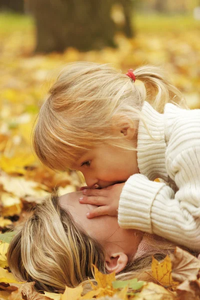 Menina bonita brincar com sua mãe na floresta de outono — Fotografia de Stock