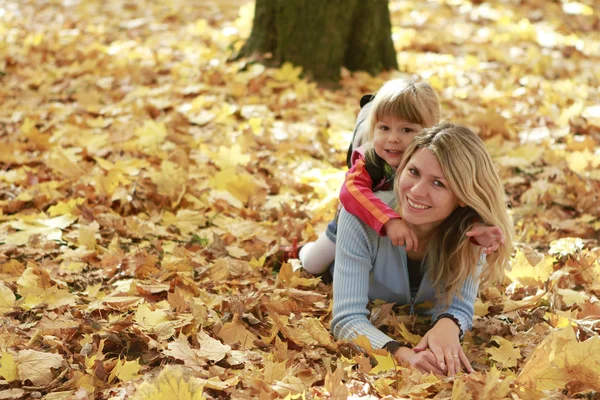 Menina bonita brincar com sua mãe na floresta de outono — Fotografia de Stock