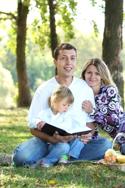 Familia leer la Biblia en la naturaleza — Foto de Stock