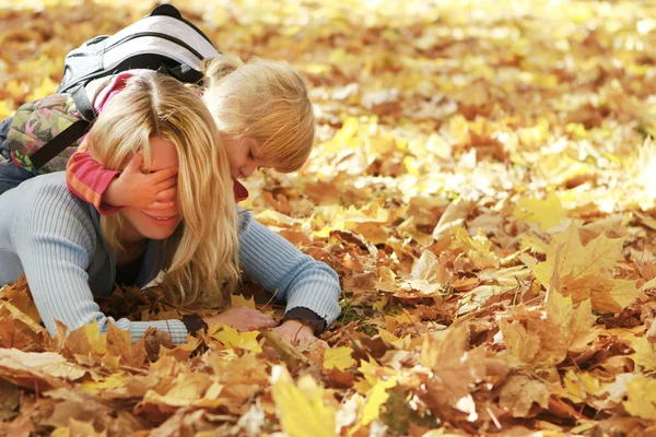 Krásná holčička hrát se svou matkou v podzimním lese — Stock fotografie