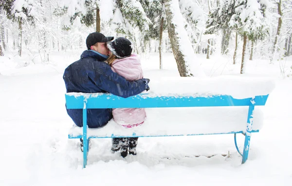 Couple in winter park on a bench — Stock Photo, Image