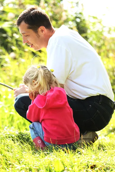 Padre con una piccola figlia al lago in stivali di gomma — Foto Stock